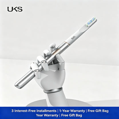 White electronic toothbrush held by a white hand sculpture on a light gray background with UKS branding.