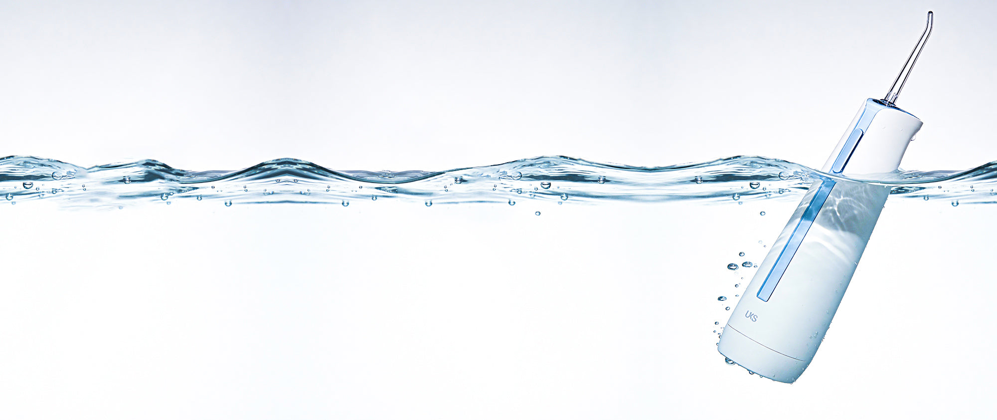 Dental water flosser with water stream on a light blue background